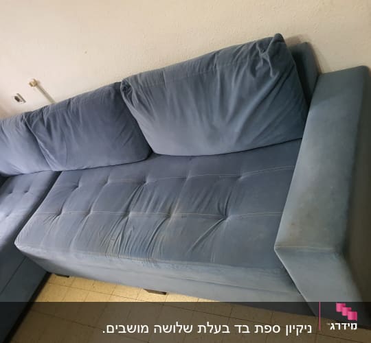 ספה כחולה עם כתמים על המושב והמשענת